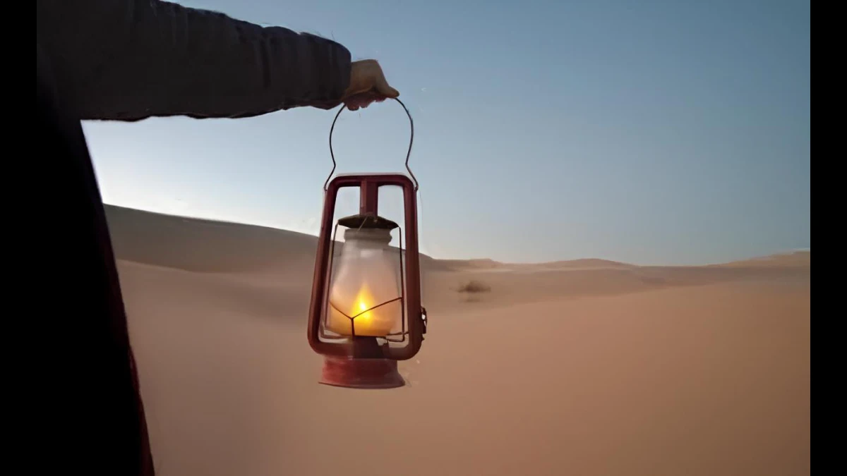 Monaco nel deserto con una lampada in mano