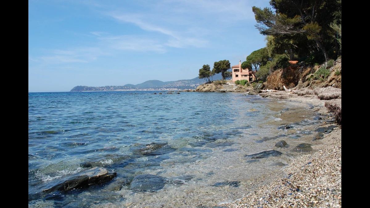 Spiaggia molto sassosa di estate col mare calmo