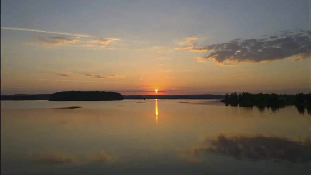 Tramonto sul lago sotto un cielo segnato da qualche nube