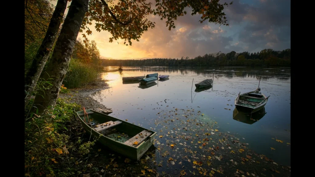 Tramonto sul lago con barche vicino alla riva
