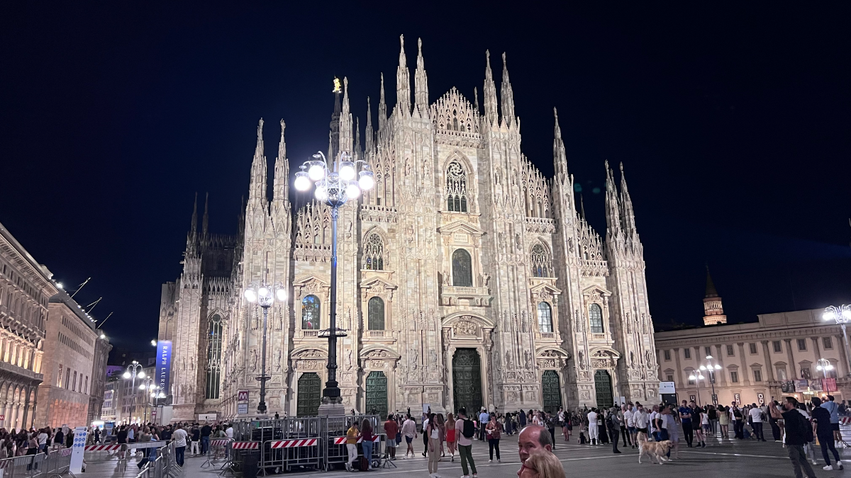 La facciata del Duomo di Milano la sera, con folla davanti