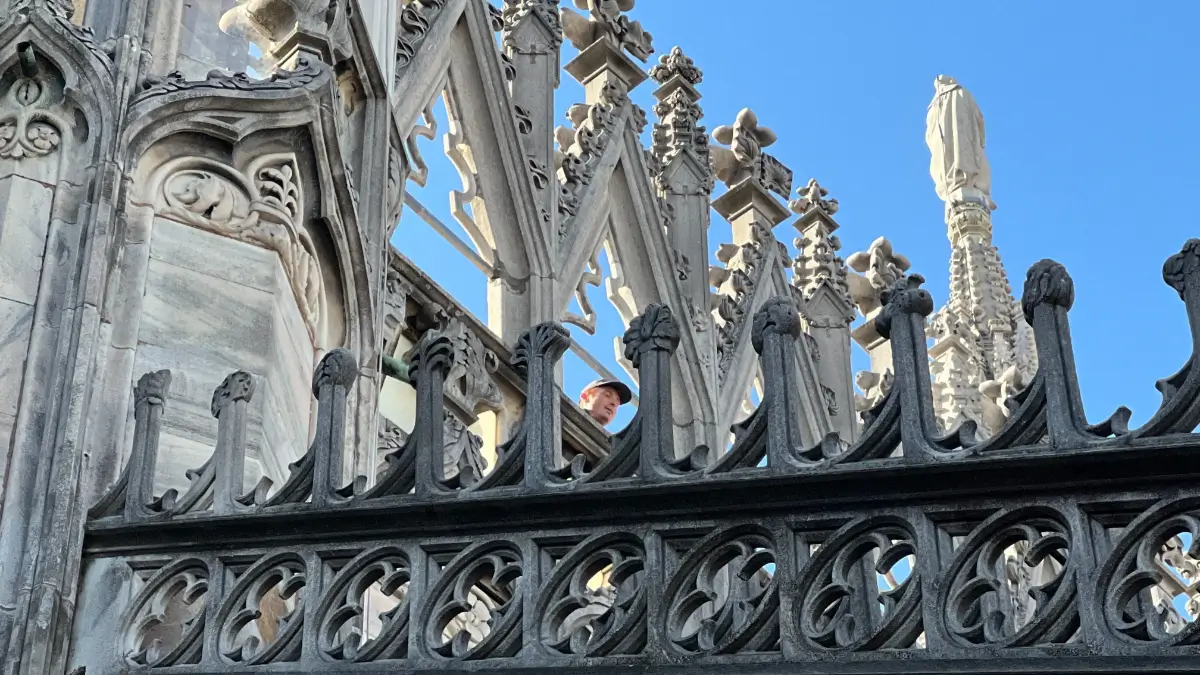 Il sole sta illuminando merli del Duomo di Milano e il volto di un turista