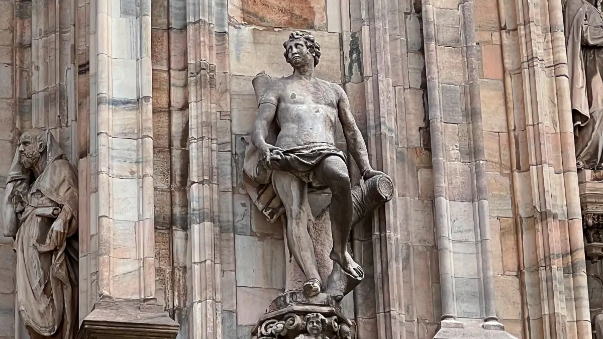 Statua della facciata del Duomo che riprende un santo che vibra per il Signore