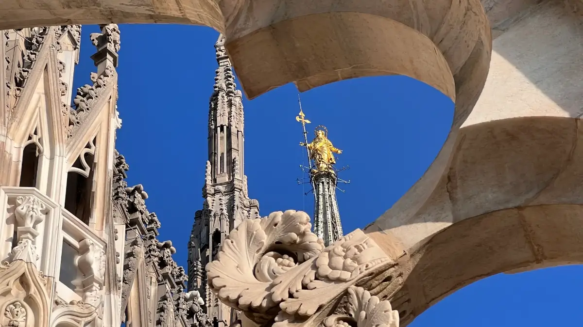 La Madonnina del Duomo di Milano inquadrata dalla voluta di una arcata